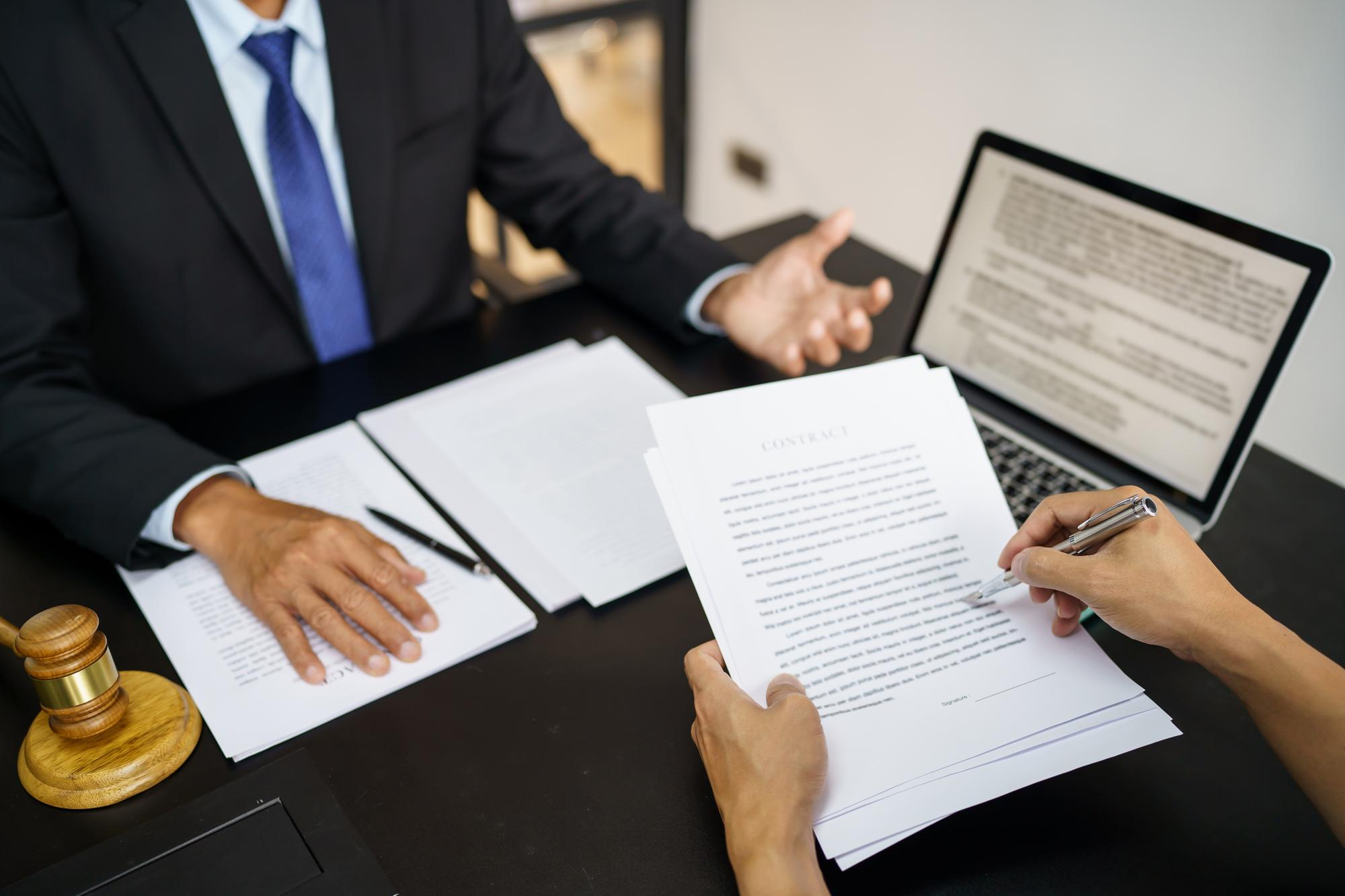 Legal counsel presents to the client a signed contract with gavel and legal law justice and lawyer concept