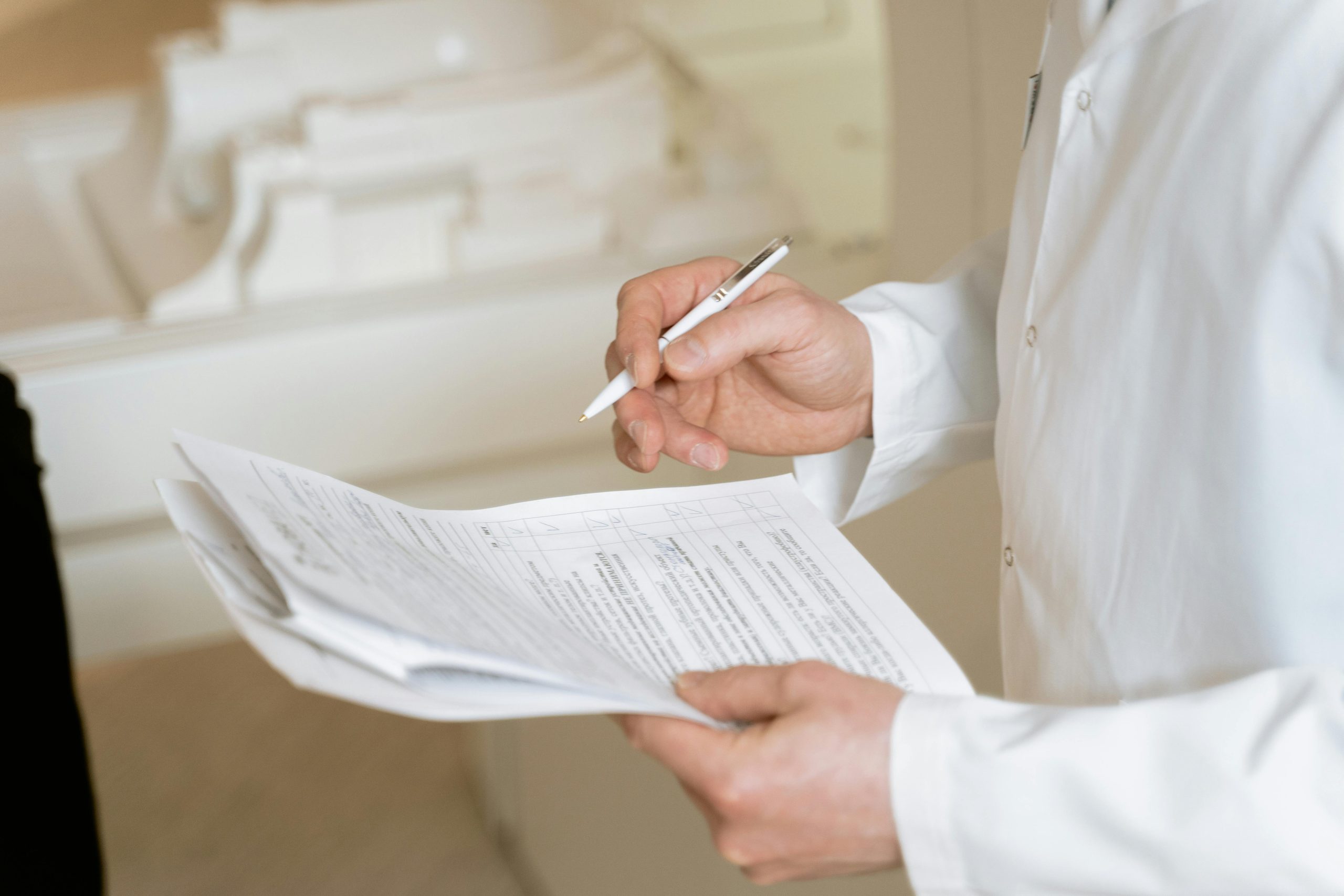 A Person in White Dress Shirt Holding a Pen and Paper A Person in White Dress Shirt Holding a Pen and Paper